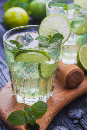 refreshing cold mojito with ice on a black wooden tableの写真素材