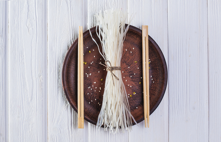 raw ingredients of oriental cuisine from rice noodles on a white wooden table.の写真素材
