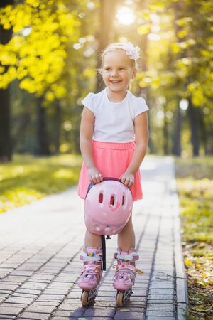 happy Little girl on roller skates at parkの写真素材