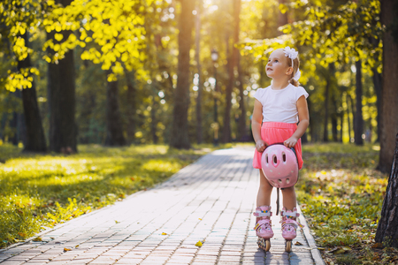 happy Little girl on roller skates at parkの写真素材