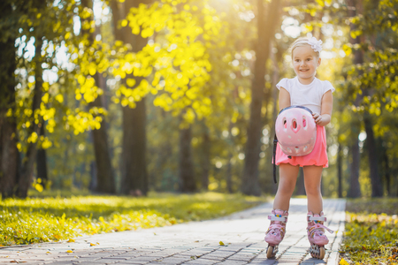 happy Little girl on roller skates at parkの写真素材