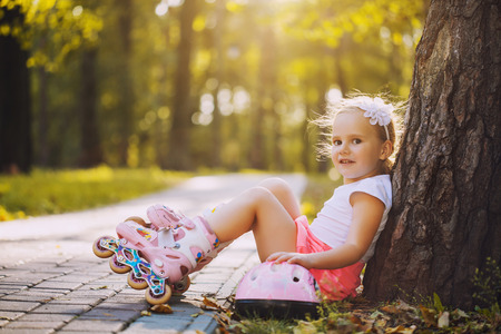 happy Little girl on roller skates at parkの写真素材