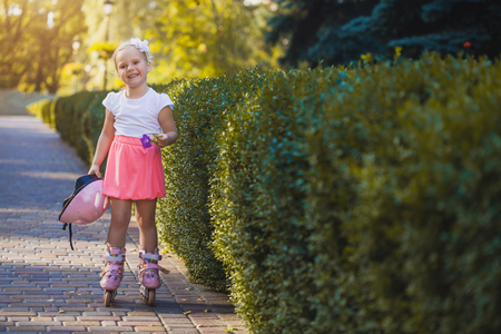 happy Little girl on roller skates at parkの写真素材