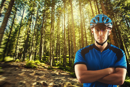 handsome cyclist portrait on a background of a picturesque forest landscapeの写真素材