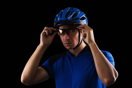 handsome cyclist portrait on a black backgroundの写真素材