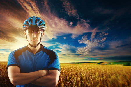 portrait of a handsome biker on a background of a picturesque countryside landscapeの写真素材