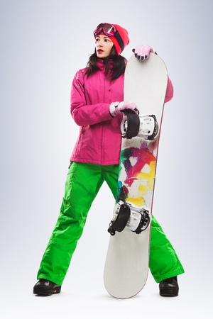 Girl with snowboard in studio on isolated background.の写真素材