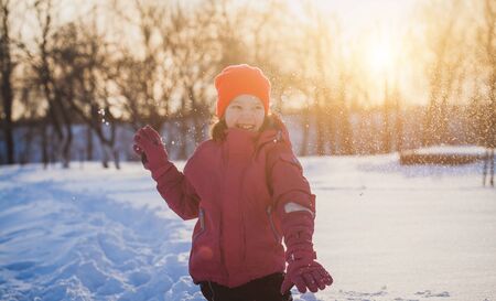 little girl is playing with snowの写真素材