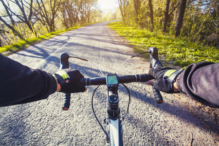 cyclist rides on a picturesque forest road on a bike.の写真素材