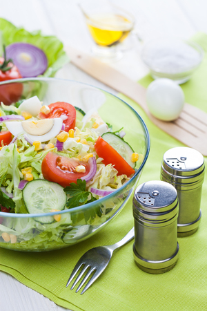 fresh spring salad of vegetables on a white wooden table.の写真素材