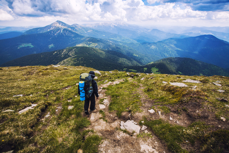 A tourist walks along a mountain meandering trailの写真素材