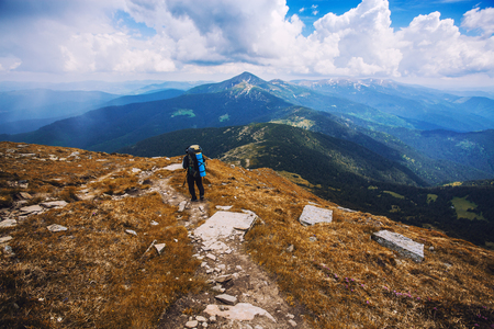 A tourist walks along a mountain meandering trailの写真素材