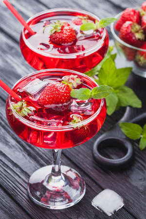 strawberry cocktail with ice and fresh mint on a black wooden table. refreshing summer drinkの写真素材