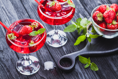 strawberry cocktail with ice and fresh mint on a black wooden table. refreshing summer drinkの写真素材