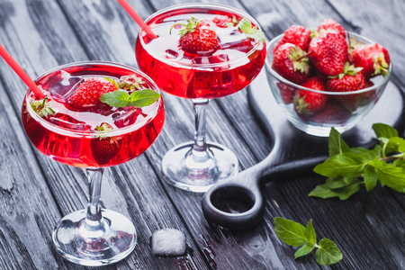 strawberry cocktail with ice and fresh mint on a black wooden table. refreshing summer drinkの写真素材