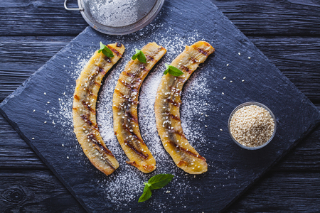 Sweet fried banana served on a black slate boardの写真素材