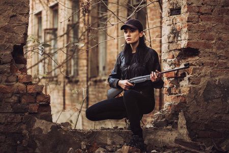 airsoft woman soldier with a rifle playing strikeball In an abandoned brick building