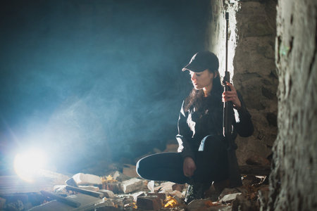 airsoft woman soldier with a rifle playing strikeball In an abandoned brick building