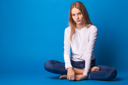 Beautiful stylish teen girl on blue background.の写真素材
