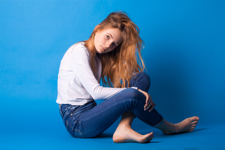 Beautiful stylish teen girl on blue background.の写真素材