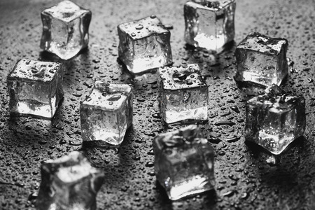 Pieces of ice cubes with water droops on black background.の写真素材