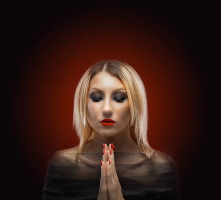 portrait of a blond woman. evening make-up on the red backgroundの写真素材