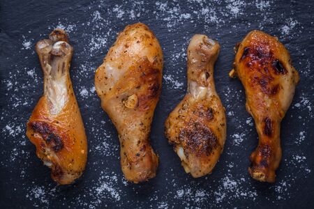 Roasted chicken legs on the black background. Top view.の写真素材