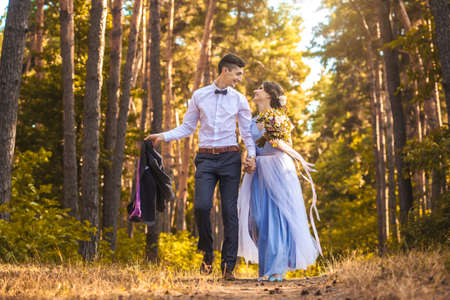 happy bride and groom walking on the autumn beachの写真素材