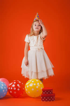 Cute girl in santa claus hat opens christmas presents. isolated on the whiteの写真素材