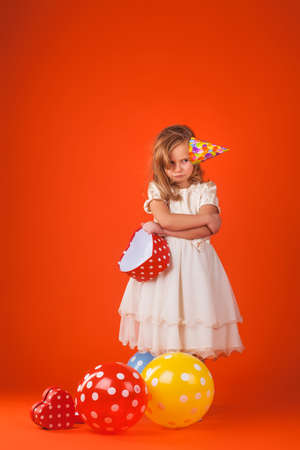 Cute girl in santa claus hat opens christmas presents. isolated on the whiteの写真素材