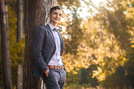 A handsome young businessman standing in the park