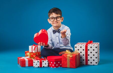 Cute kid with gifts on the blue backgroundの写真素材