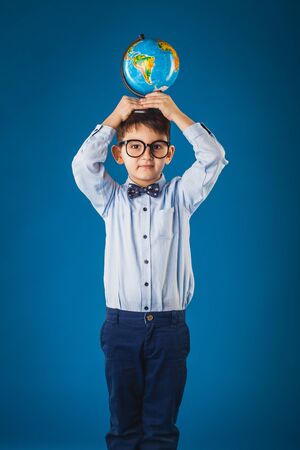 Cute boy with a globe on a blue background.の写真素材