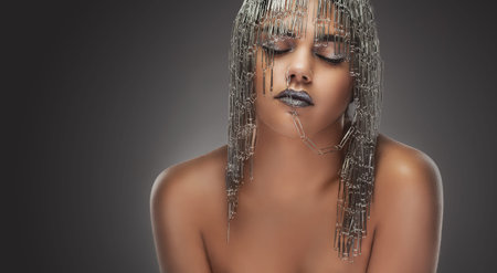 Beautiful brunette woman. creative evening make-up with steel hair on the gray bokeh background