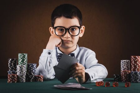 Little kid boy playing poker in a casino.の写真素材