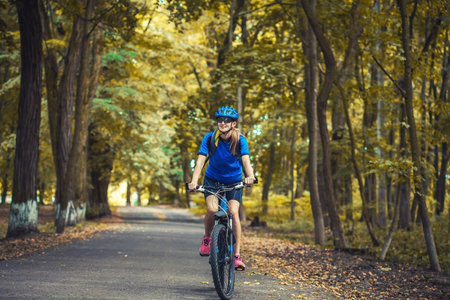woman cyclist rides mountain bike forest trails.