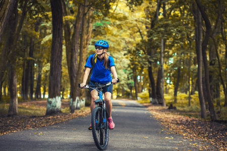 woman cyclist rides mountain bike forest trails.