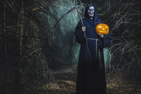 Woman devil ghost demon costume horror and scary she holding pumpkin in hand in the forest. The vampire ghost people, Happy Halloween day conceptの写真素材
