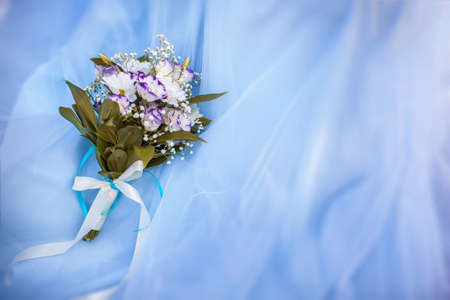 Wedding bouquet of eustomas and chrysanthemums on a blue tulle backgroundの写真素材