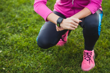 woman runner measures heart rate while jogging using smart watch