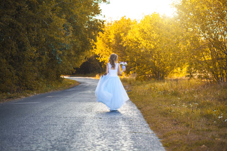 bride with a bouquet is walking the green parkの写真素材