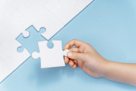 a childs hand makes the last missing piece of the puzzle. business concept