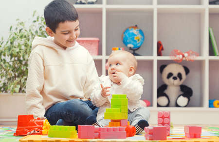 kids playing with colourful building blocks at home or kindergartenの写真素材