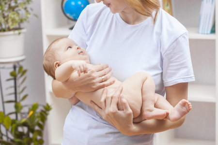 young happy woman holding a newborn baby in her arms