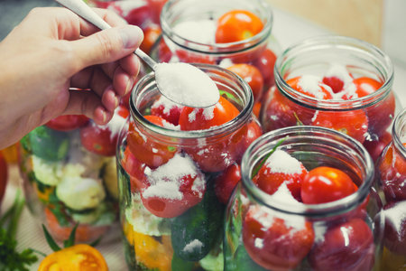 The process of preserving cucumbers and tomatoes for the winter.の写真素材