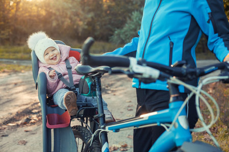 Young beautiful mother with small baby on bicycle.の写真素材