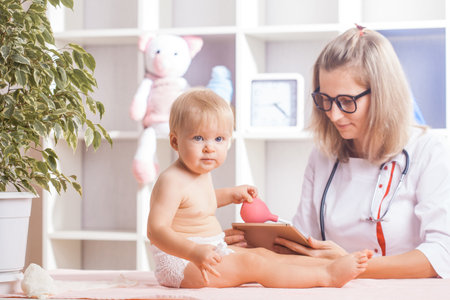 Woman Doctor examining little baby in clinic. Baby health medicine conceptの写真素材