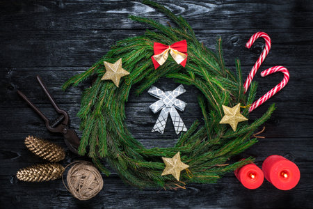 Christmas decor with pine needles, candles, sweets on the black wooden table. Festive handmadeの写真素材