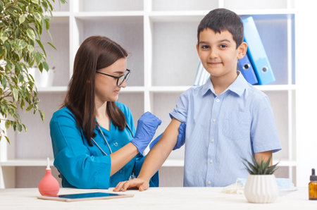 vaccination of children, a little boy at a woman doctor's appointment, an injection in the armの写真素材