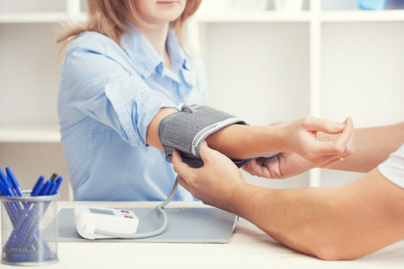 man doctor measures blood pressure in his office. scheduled medical examinationの写真素材